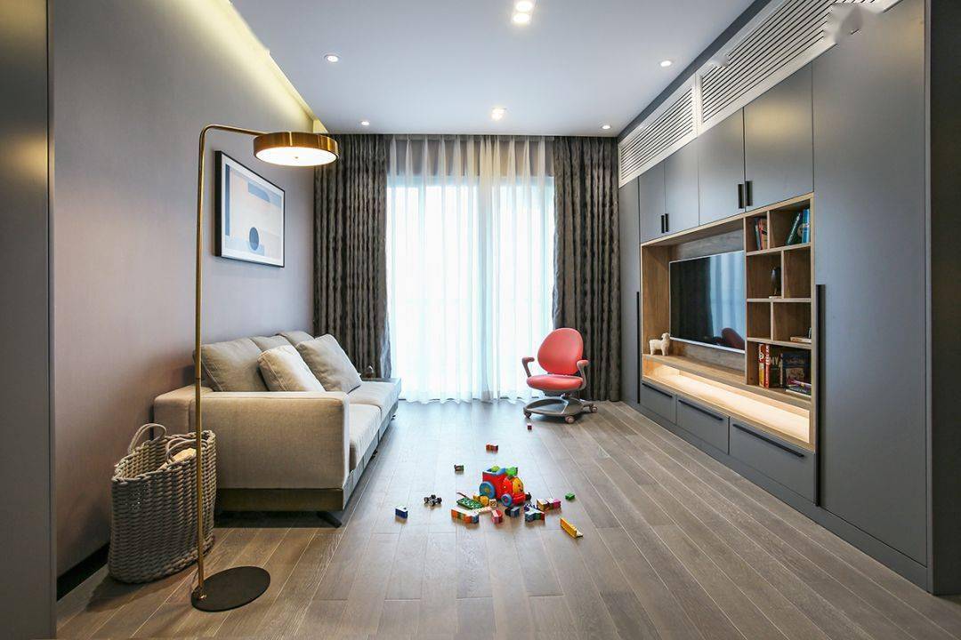 今天分享的是一套建筑面積102平米的現(xiàn)代輕奢風(fēng)三居室案例，屋主夫妻和女兒、母親一家四口人居住，整體來(lái)說(shuō)是比較緊湊的剛需三房案例，設(shè)計(jì)師以輕松、時(shí)尚的灰色調(diào)作為主色，搭配格調(diào)滿滿的木質(zhì)家具，營(yíng)造出簡(jiǎn)約、輕奢的感覺(jué)。    平面布置圖    入戶玄關(guān)和餐廳連在了一起，利用了入戶門側(cè)方的墻面來(lái)做上一整墻的柜子，把鞋柜和餐邊柜結(jié)合在一起使用，更為省空間。    復(fù)古的木質(zhì)餐桌椅到灰色調(diào)的背景，金屬質(zhì)感的吊燈，整個(gè)餐廳看起來(lái)非常有格調(diào)感。在餐桌椅側(cè)方加上隔板的設(shè)計(jì)，增強(qiáng)儲(chǔ)物能力。    位于餐廳另一側(cè)的就是客廳空間了，客廳的茶幾被舍棄，中間留空方便作為孩子的娛樂(lè)區(qū)，米色布藝沙發(fā)和暖灰色背景墻讓人感覺(jué)更加溫馨。    客廳的電視背景墻則是被利用起來(lái)做了收納，整墻的柜子留空電視周邊的部分區(qū)域，加上藏光之后使用更方便，看起來(lái)也更大氣。    廚房?jī)?nèi)部的櫥柜延續(xù)了客餐廳的柜子顏色，深灰色的大理石墻磚搭配灰色的啞光地磚，整個(gè)廚房看起來(lái)很有現(xiàn)代感。    臥室選擇了以藍(lán)灰色為主，在臥室頂部吊頂內(nèi)加上藏光，用吊燈、臺(tái)燈等代替主燈，讓臥室看起來(lái)更為簡(jiǎn)潔。    在主臥室里還有一個(gè)迷你的衣帽間，U字形布局的柜子把角落空間充分用上。衣帽間外的床頭柜改成了梳妝臺(tái)，使用起來(lái)更加方便。    老人房選擇了榻榻米床組合衣柜和書桌的設(shè)計(jì)，榻榻米的安全性會(huì)更高一些，加上一張書桌也方便屋主母親看看書。    衛(wèi)生間內(nèi)部是三角形的布局方案，鉆石形的淋浴房做在了轉(zhuǎn)角處，兩側(cè)擺放洗手臺(tái)和馬桶。洗手臺(tái)上方的鏡柜做了藏光的設(shè)計(jì)，看起來(lái)更時(shí)尚。